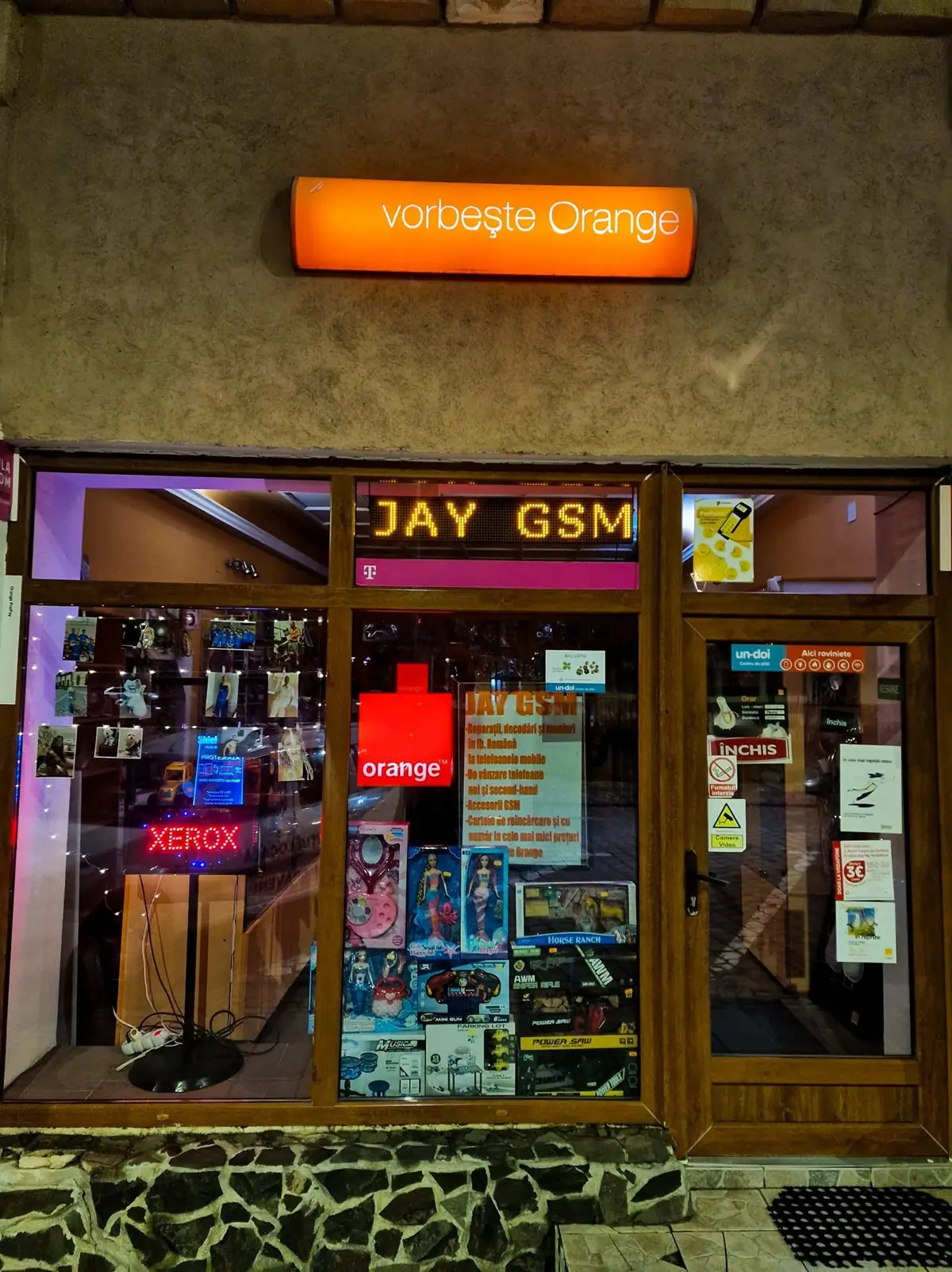 Magazinul JAY GSM din Dumbrăveni, seara, cu firma luminoasă JAY GSM