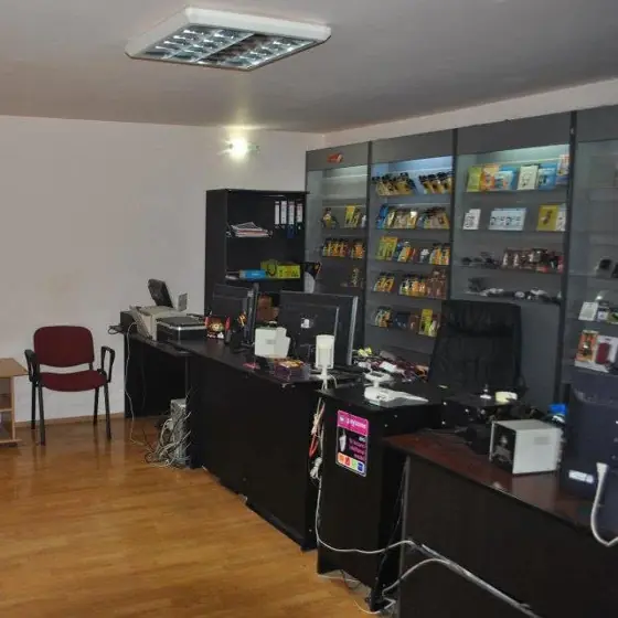 Interiorul magazinului JAY GSM, cu tejgheaua de service și vitrinele de accesorii