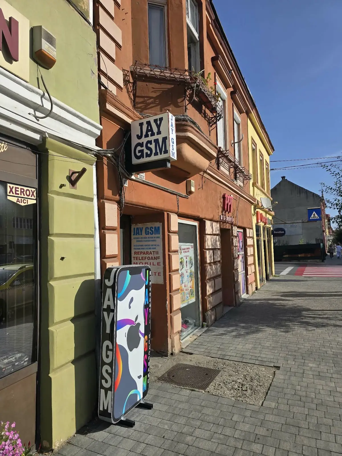 Intrarea JAY GSM din Sighișoara, cu firma JAY GSM și totemul în formă de telefon