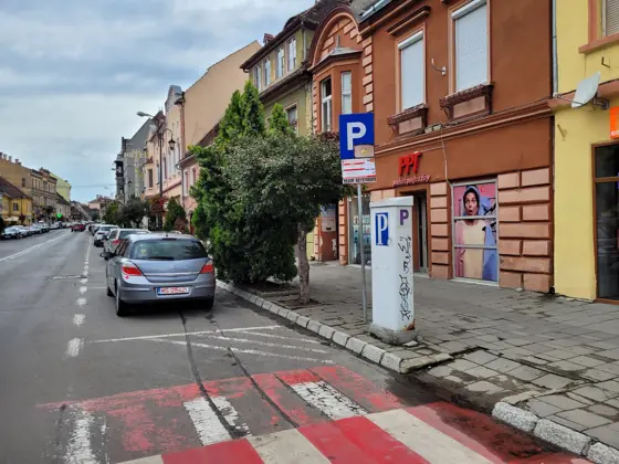 Strada 1 Decembrie 1918 din Sighișoara, cu parcare în fața magazinului